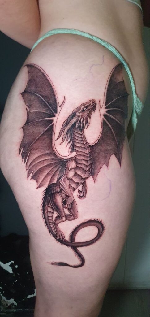 tatuaje realismo blackwork dragón y sus alas