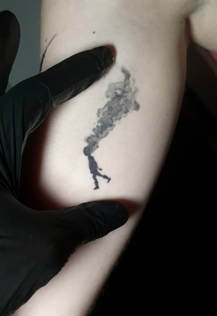 Tatuaje minimalista niño desvaneciéndose