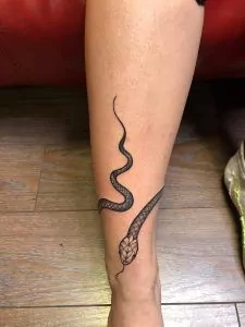 serpiente realista enrollada en la pierna