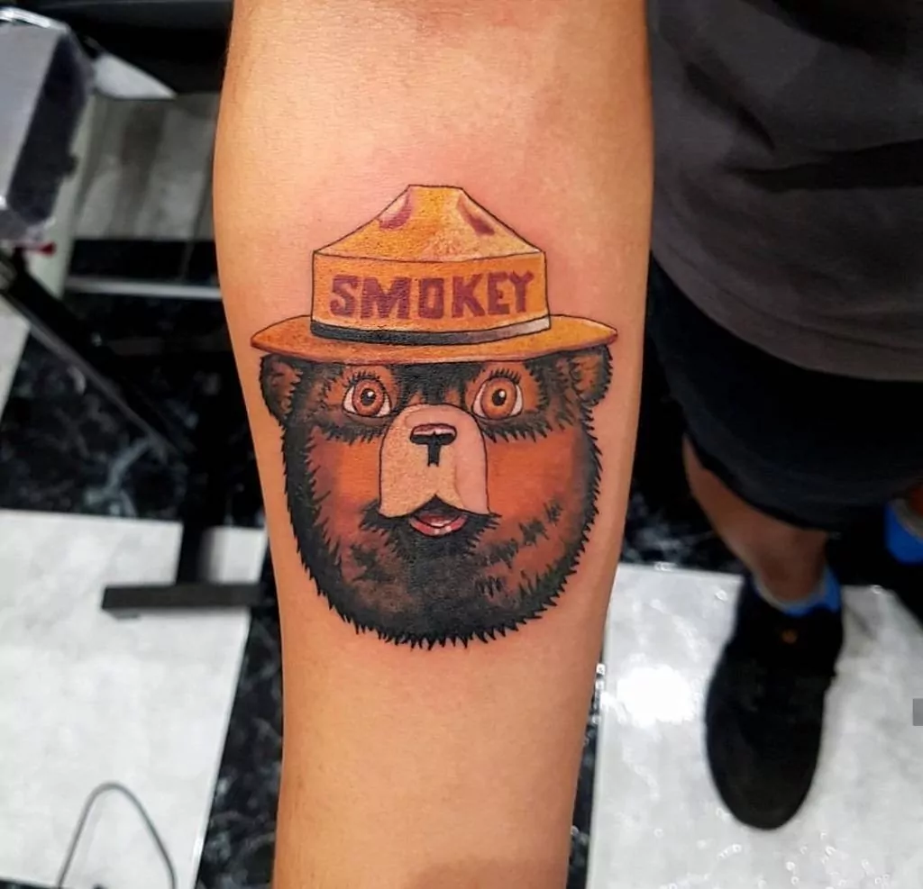 Tatuaje del oso Smokey bear a color en el antebrazo