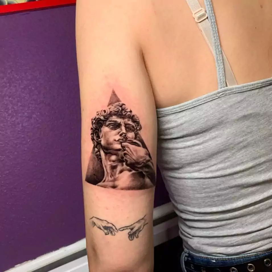 Tatuaje escultura griega estilo realismo en el brazo