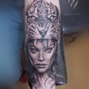 Rostro de mujer con cabeza de jaguar en el antebrazo estilo realismo