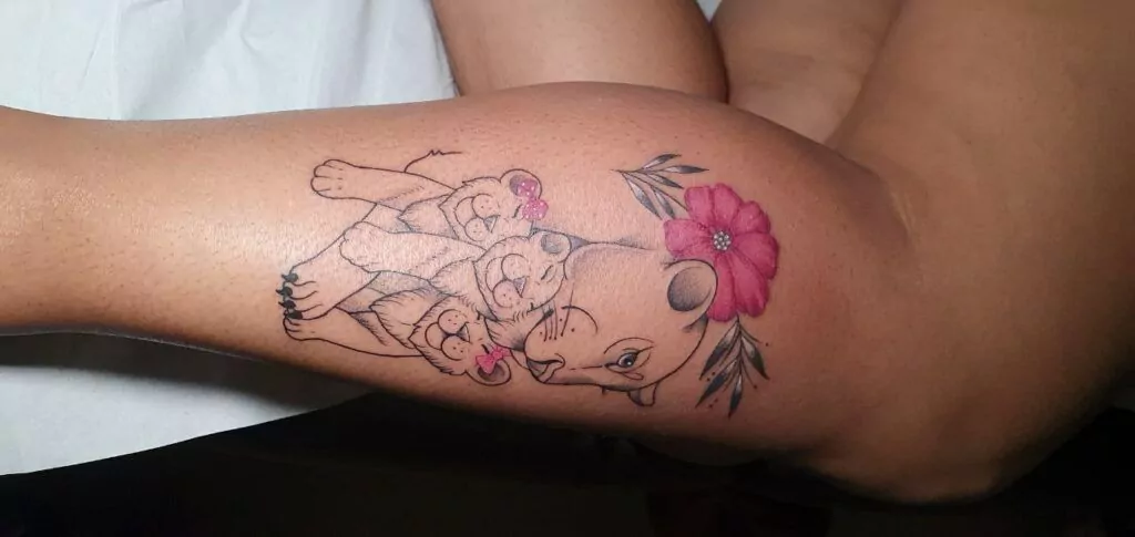tatuaje de una leona con 3 leones cachorros y una flor