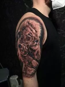 Tatuaje león y su cachorro estilo realista en el brazo