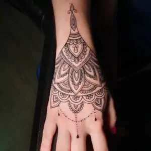 Tatuaje mándala de línea fina en la mano