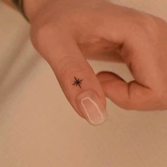 tatuaje minimalista estrella en el dedo pulgar