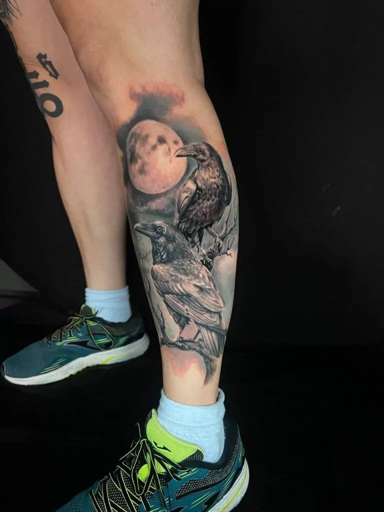 tatuajes de dos cuervos en la pierna estilo realista