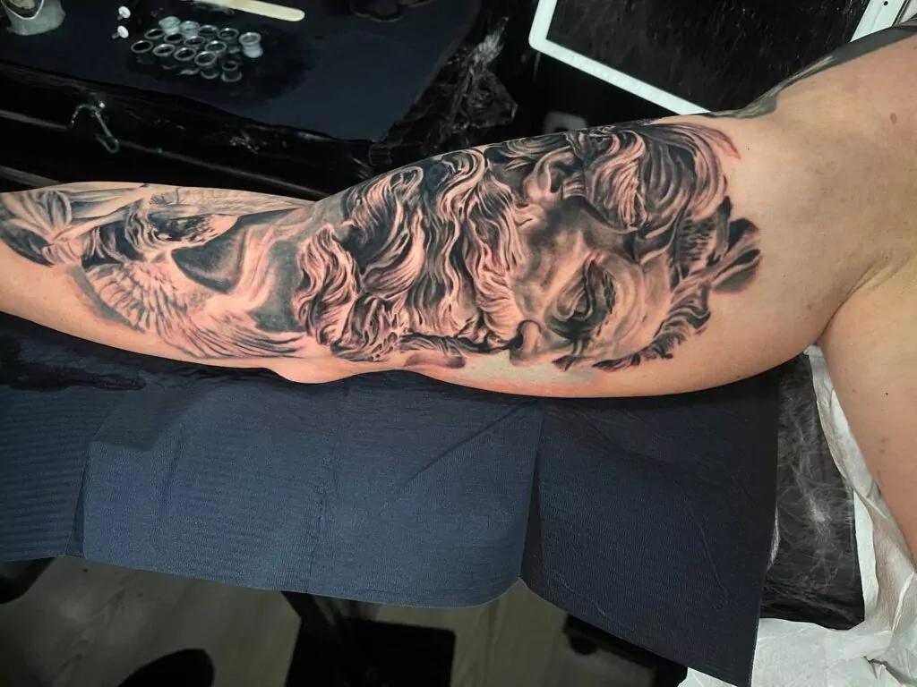 tatuaje dios griego estilo realista en el brazo