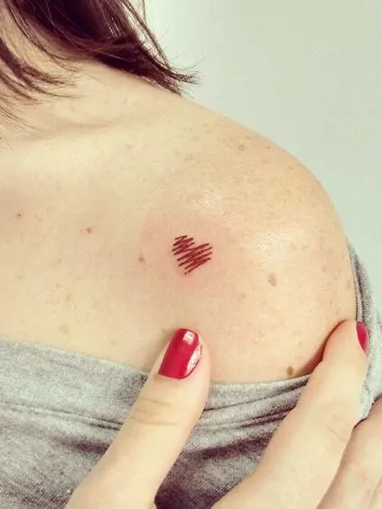 tatuaje minimalista corazón rojo degradado en el hombro