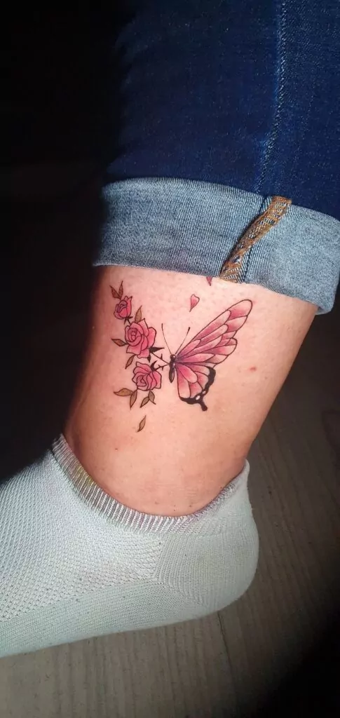 tatuaje minimalista mariposa en flores